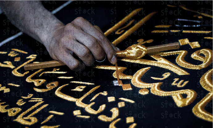 A man writing in Arabic calligraphy - stock image