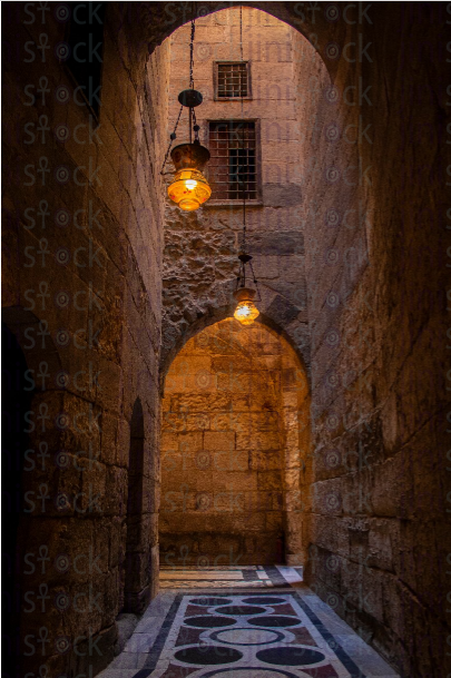 An internal corridor of the mosque with illuminated lamps - stock image