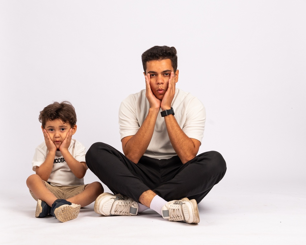 father and son setting on the floor - stock image