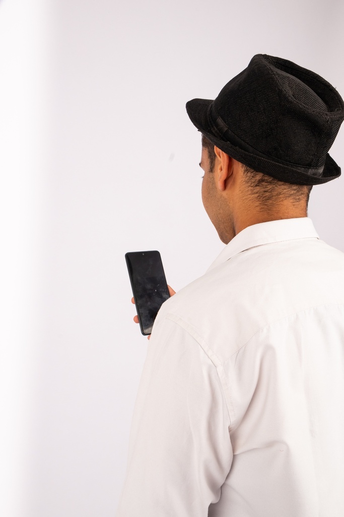 man looking at his phone over the shoulder shot - stock image