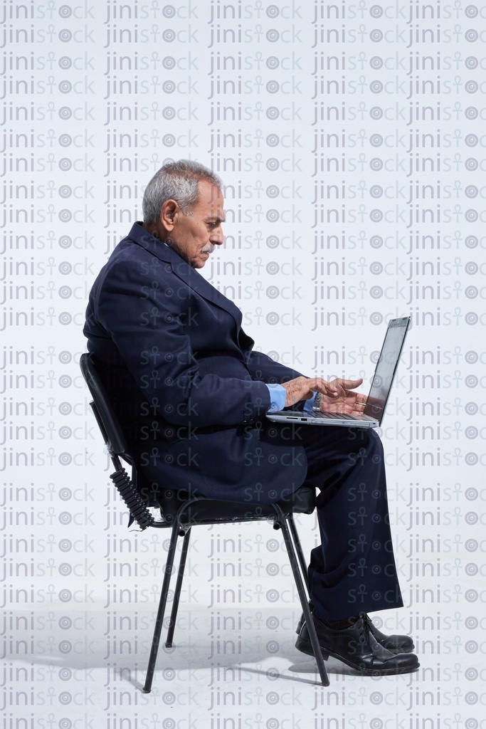 Old man typing on the laptop side view