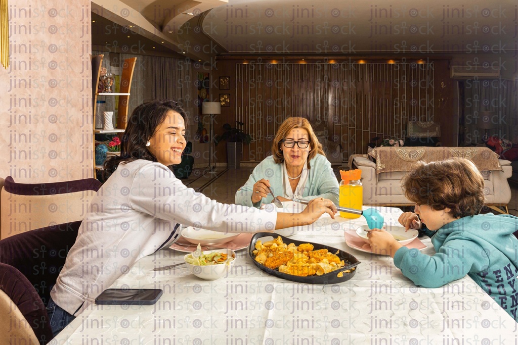 Mother, grandmother and grandson on the dinning table eating