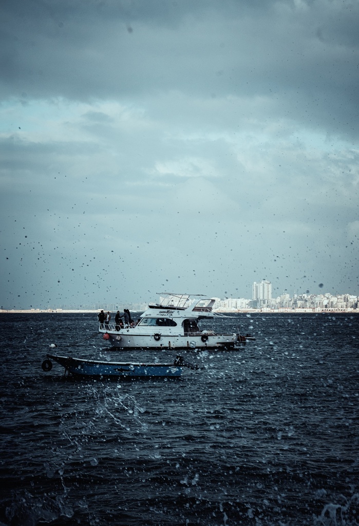 A yacht and a small boat in the middle of the sea - stock image