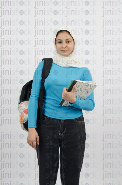 A girl wearing a hijab carrying school books and a backpack - stock image