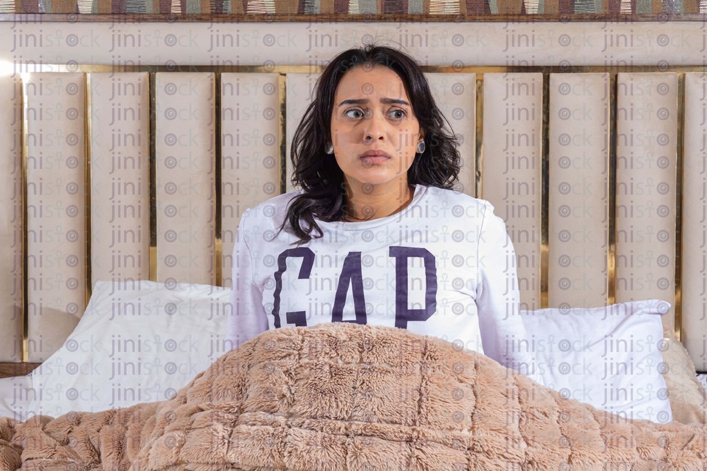 woman waking up worried in her bed