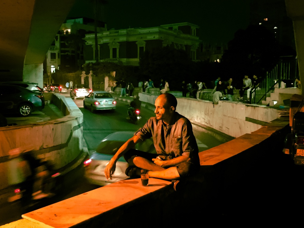 man sitting on the existing October Bridge in Tahrir AT NIGHT