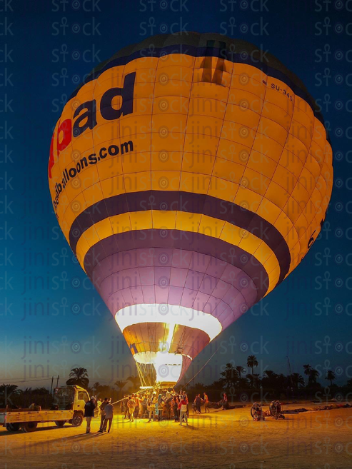 Air balloon in Luxor flying over a green field. farming lands