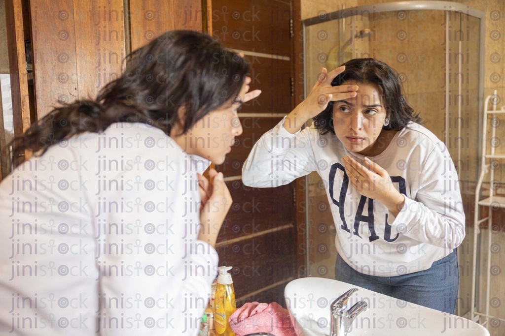 Egyptian woman checking her skin for wrinkles