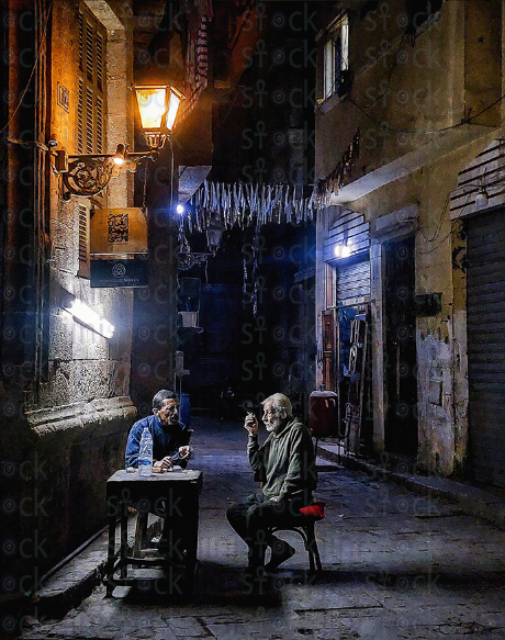 old men are taking on a cafe shop in an old street during the night