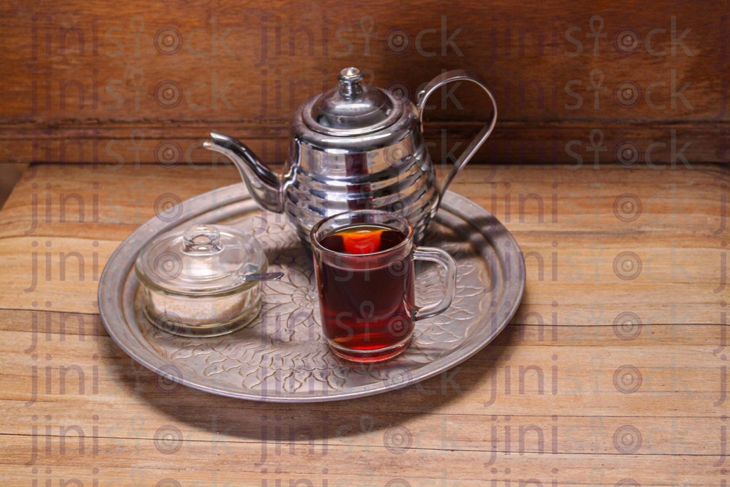 tray of hot tea and metal pod on a wood table