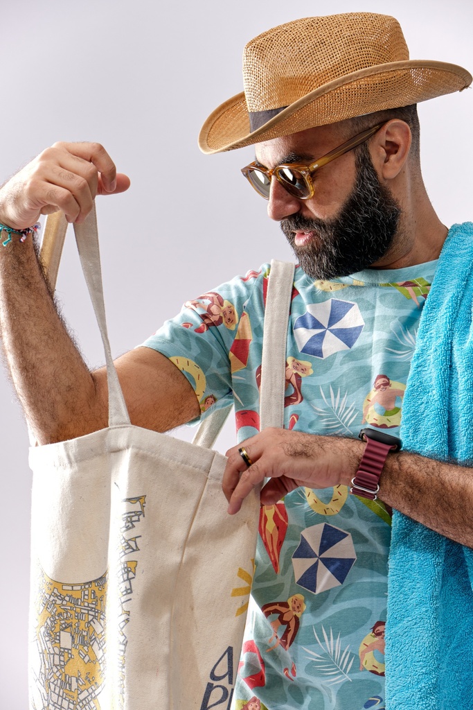 man looking for something in his beach bag.