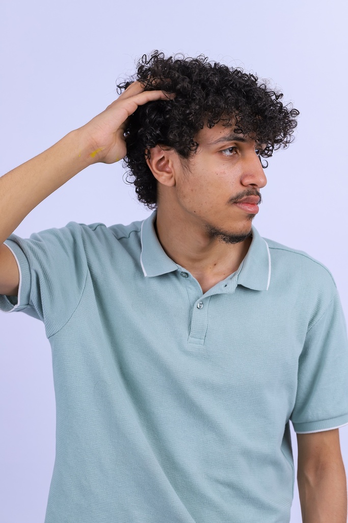 young man with curly hair side view.