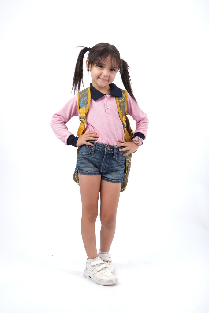 little girl in school uniform smiling with two ponytails