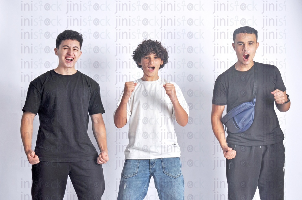 Three teen boys cheering for their  Football team.