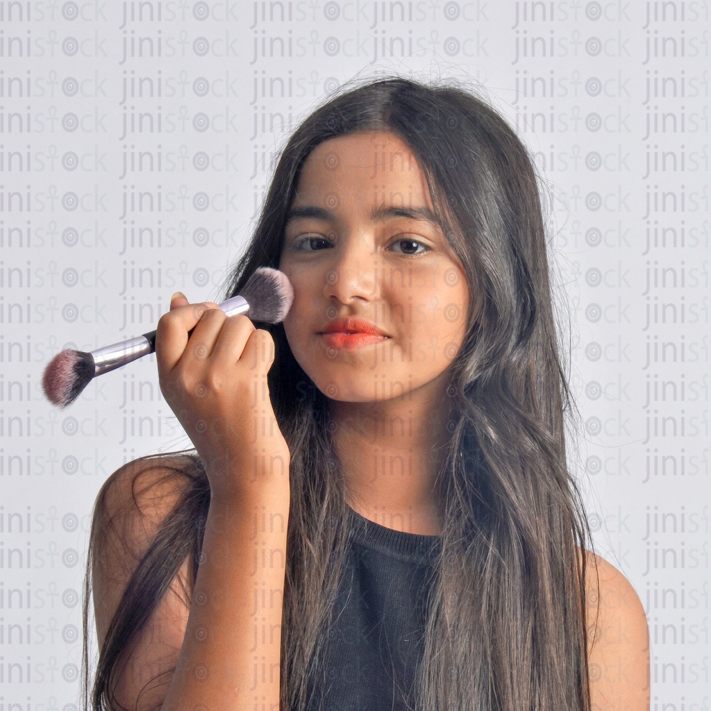 A young girl putting Makeup on her face close up shot