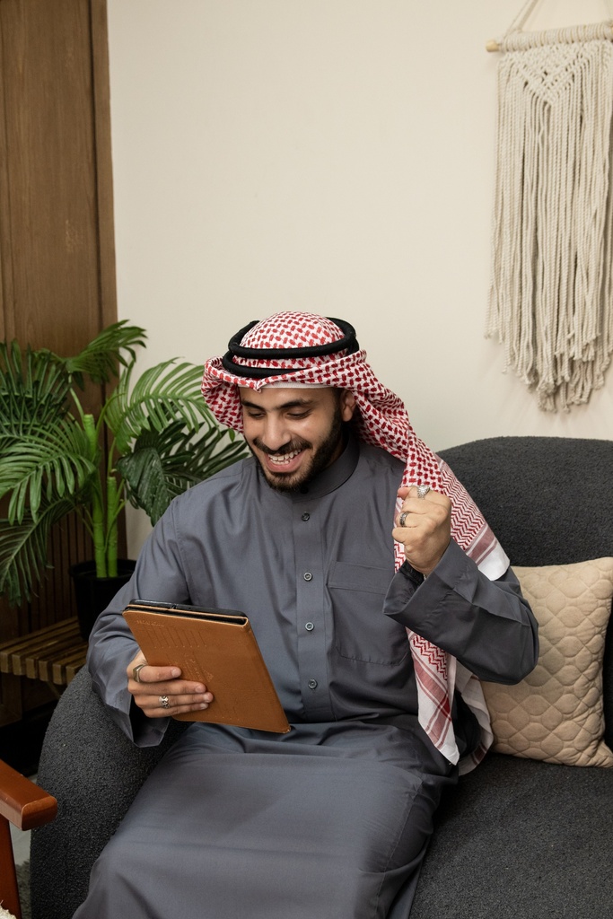 A young Gulf man is happy with what he sees on the iPad