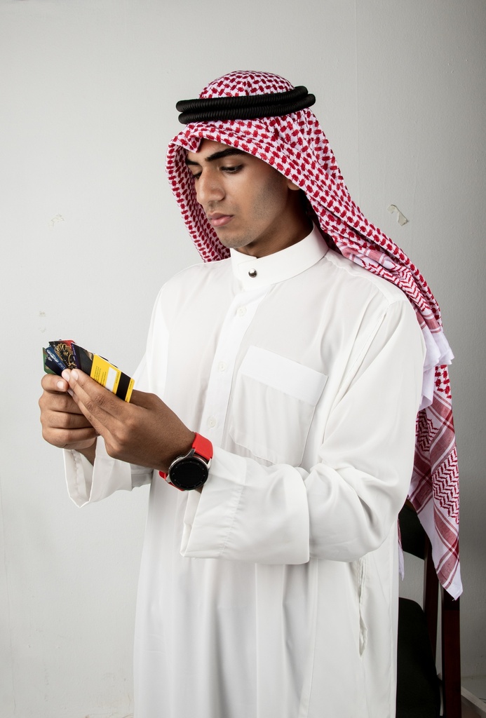 young man from the gulf khaliji checking out visa cards