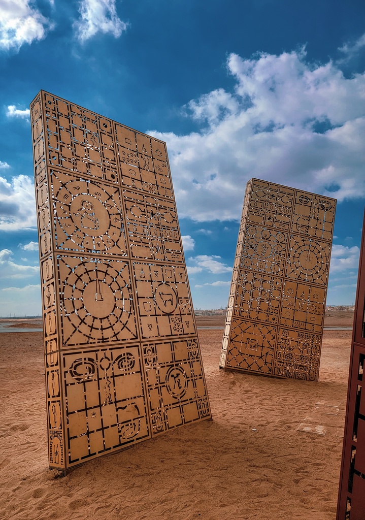 Two Gold pharaonic illustrations boards shining under the sun in the desert