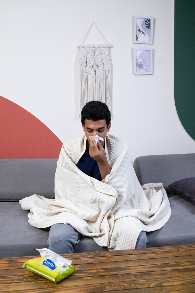 A tired and sick young man sitting on the sofa