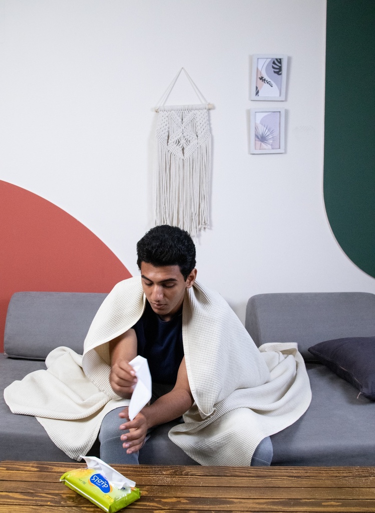 A sick young man uses tissues