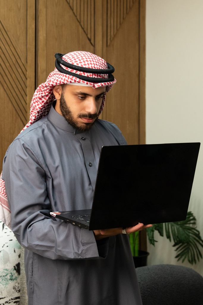 A young Gulf man browsing on his laptop