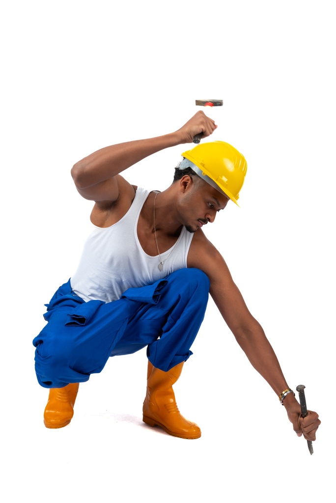 Egyptian worker in a uniform hammering a nail