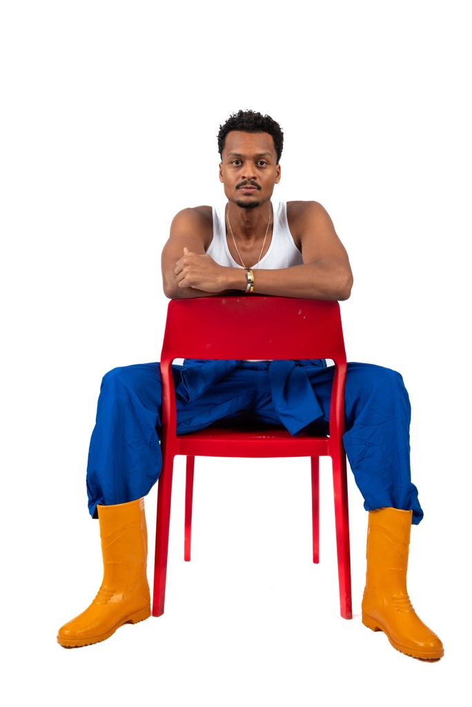 man worker in a blue working uniform sitting on a chair