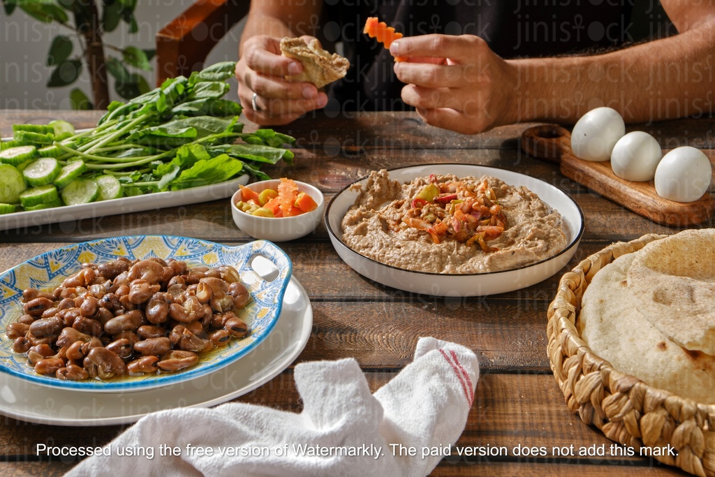 man dipping bread in foul