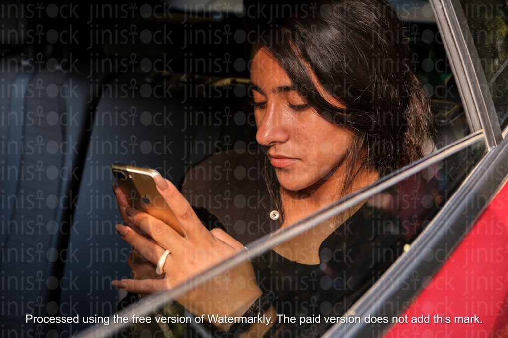 woman looking at her mobile in a car