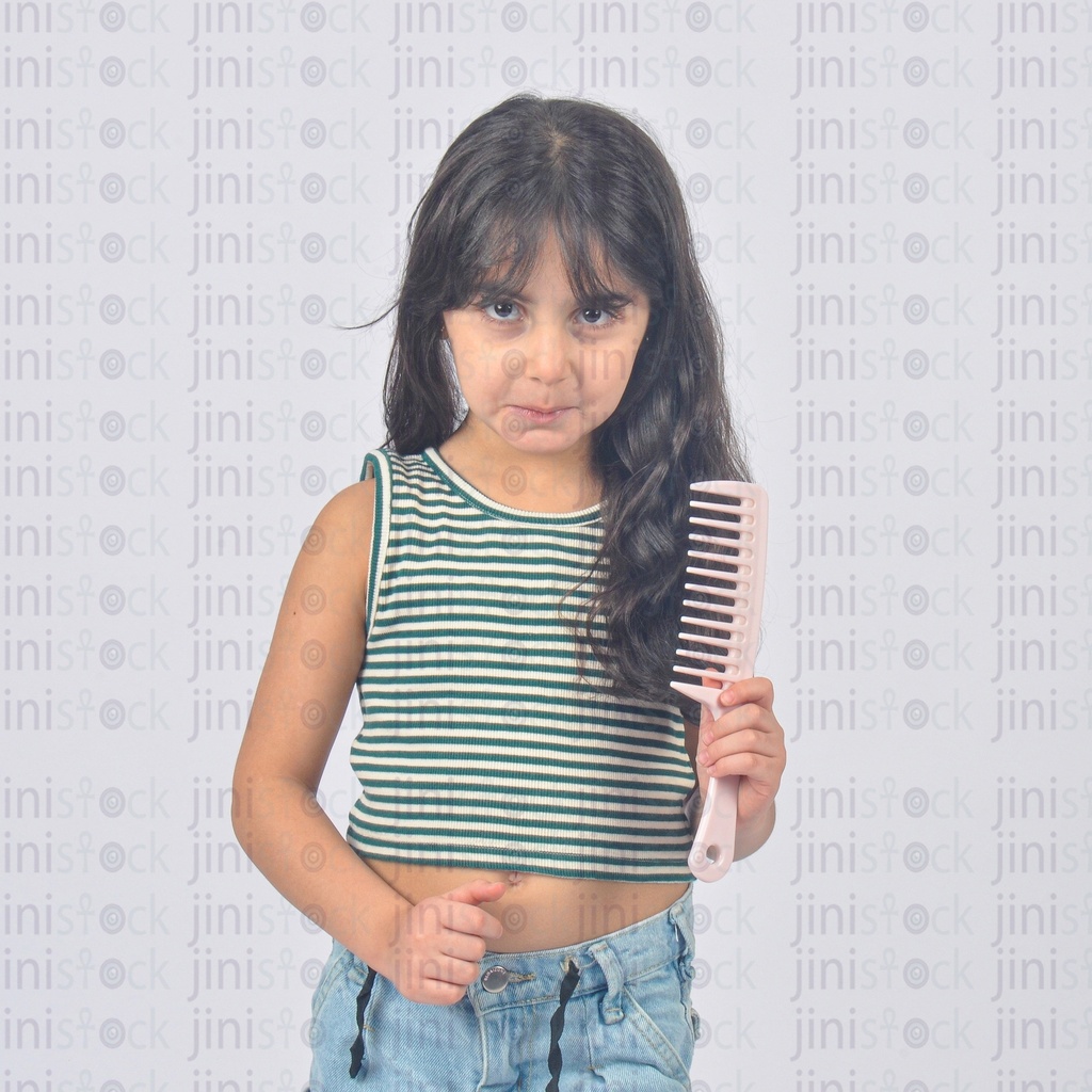 A child has long hair holding a comb and sad