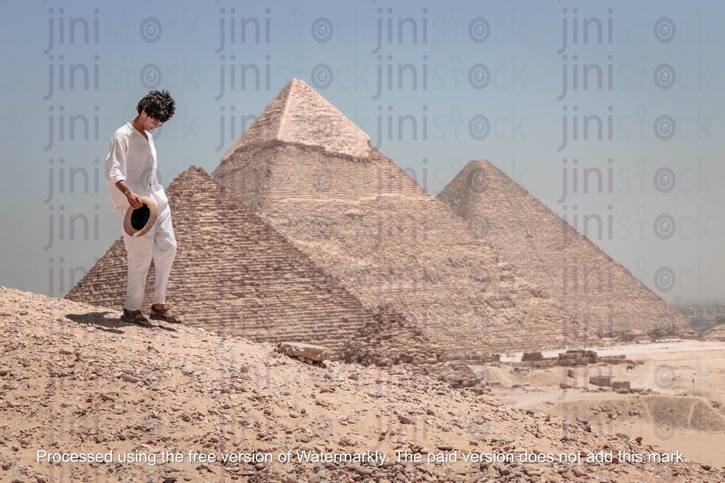 young man standing infront of the pyramids