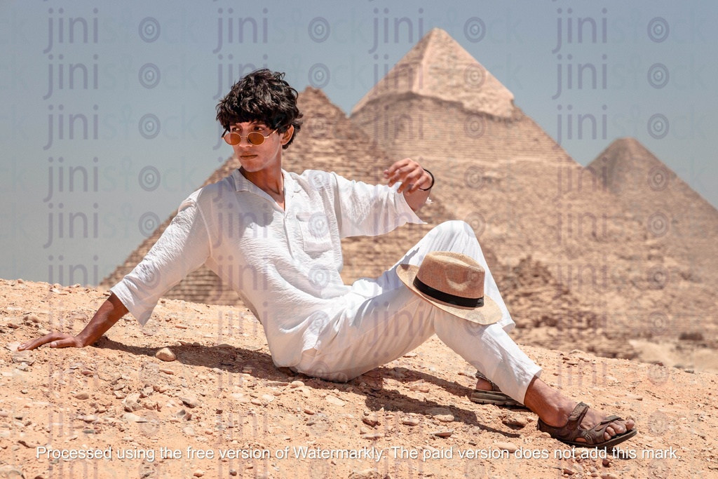 Young man setting infront of the pyramids