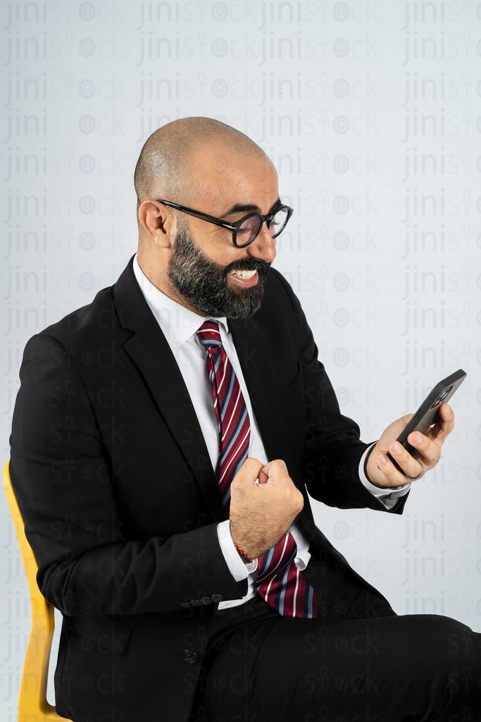 business man looking happy and excited at his mobile