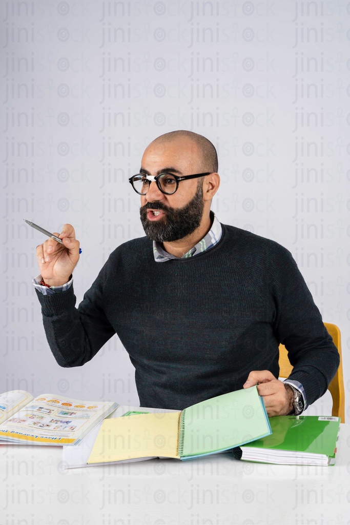 teacher sitting behind the desk talking to the kids