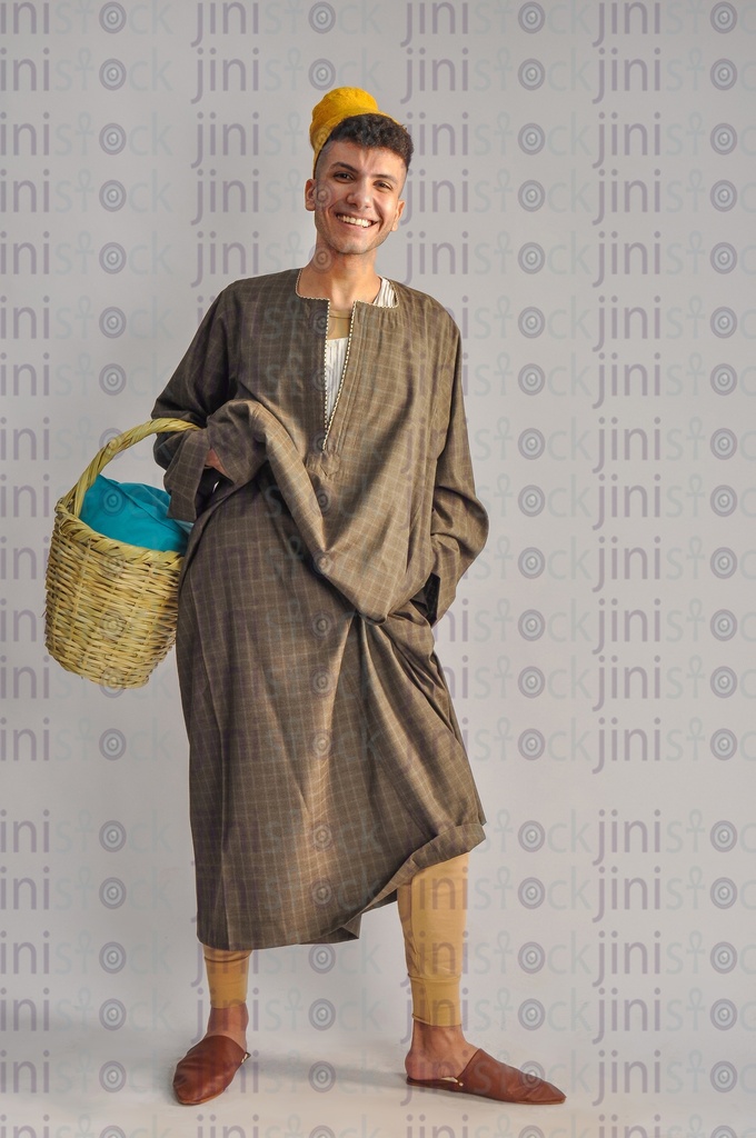 An Egyptian farmer holding a basket in his hand.