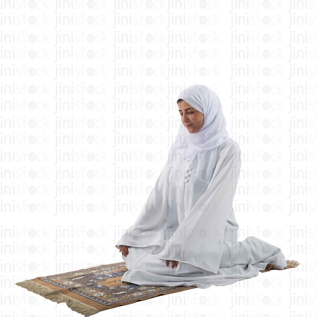 woman in white praying on a carpet