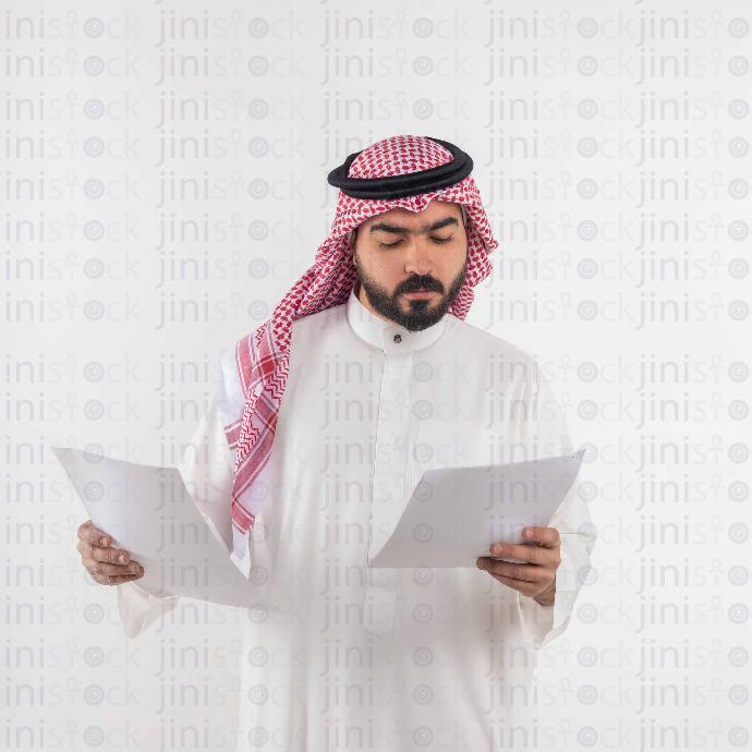 a man from gulf reading papers stock image with high quality