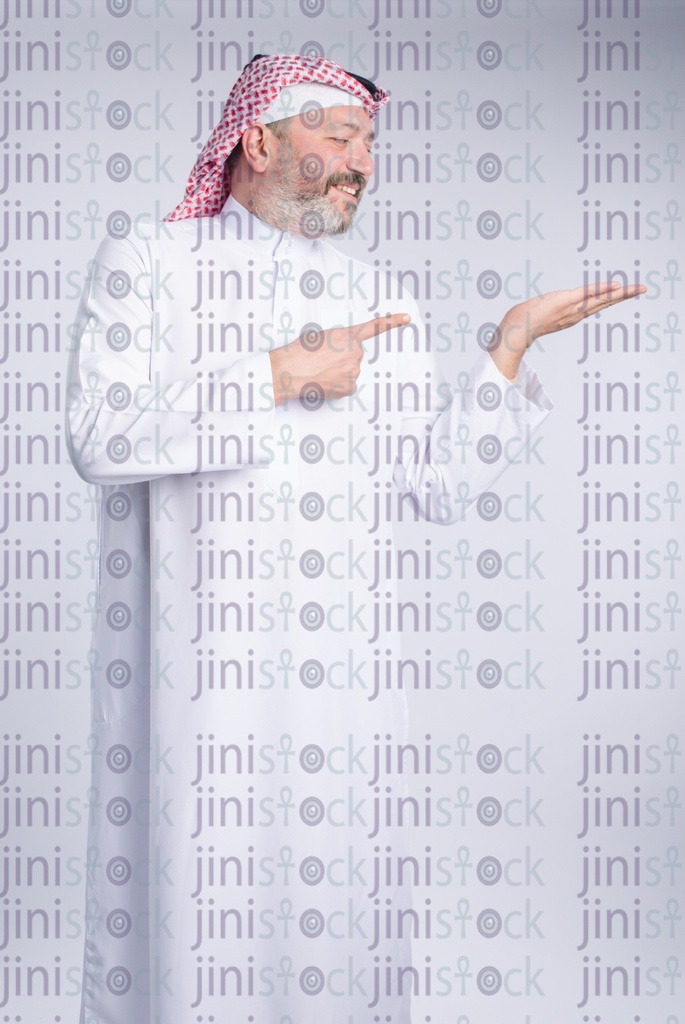 khaliji man is looking at something in his hands