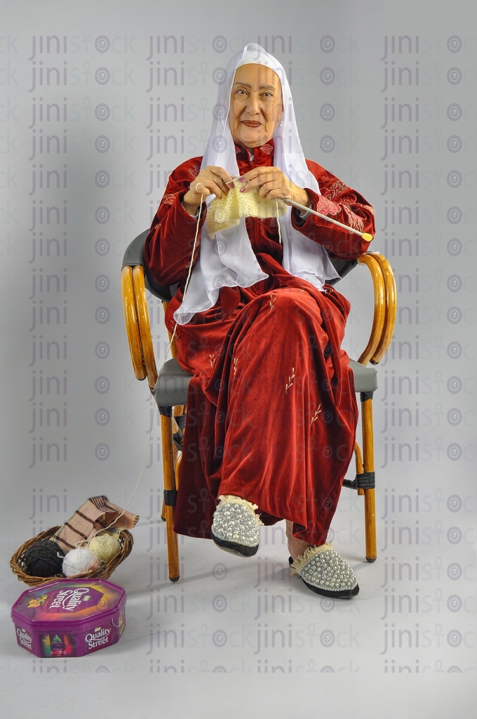 An old Egyptian woman working with a knitting needle