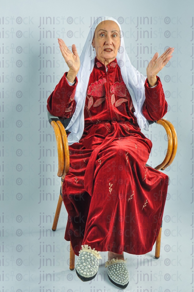 An Egyptian woman sitting on a chair and clapping