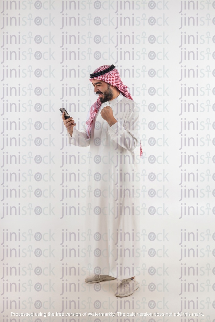 Khaliji man looking at his phone happy winning