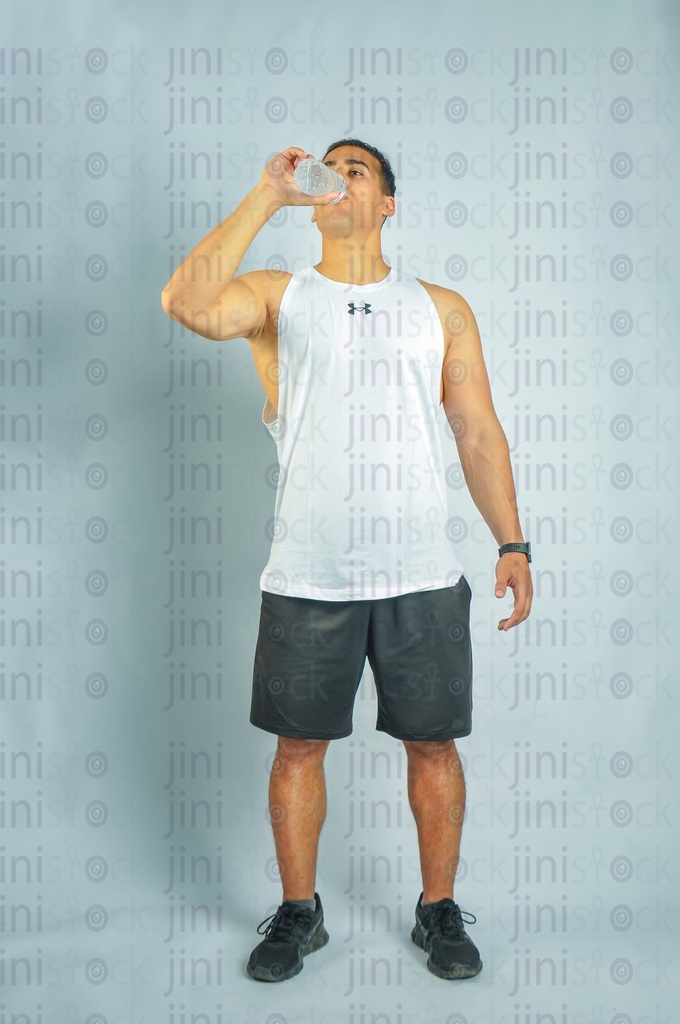 An athletic man drinking water.