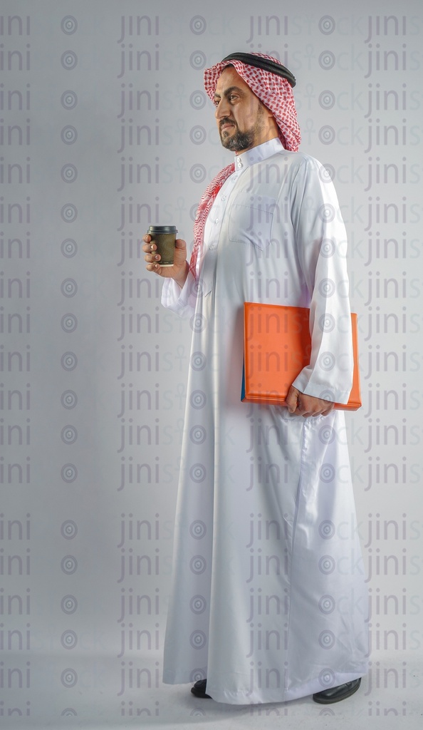 A man from gulf Saudi or Emirati holding a cup of coffee and a folder of work papers