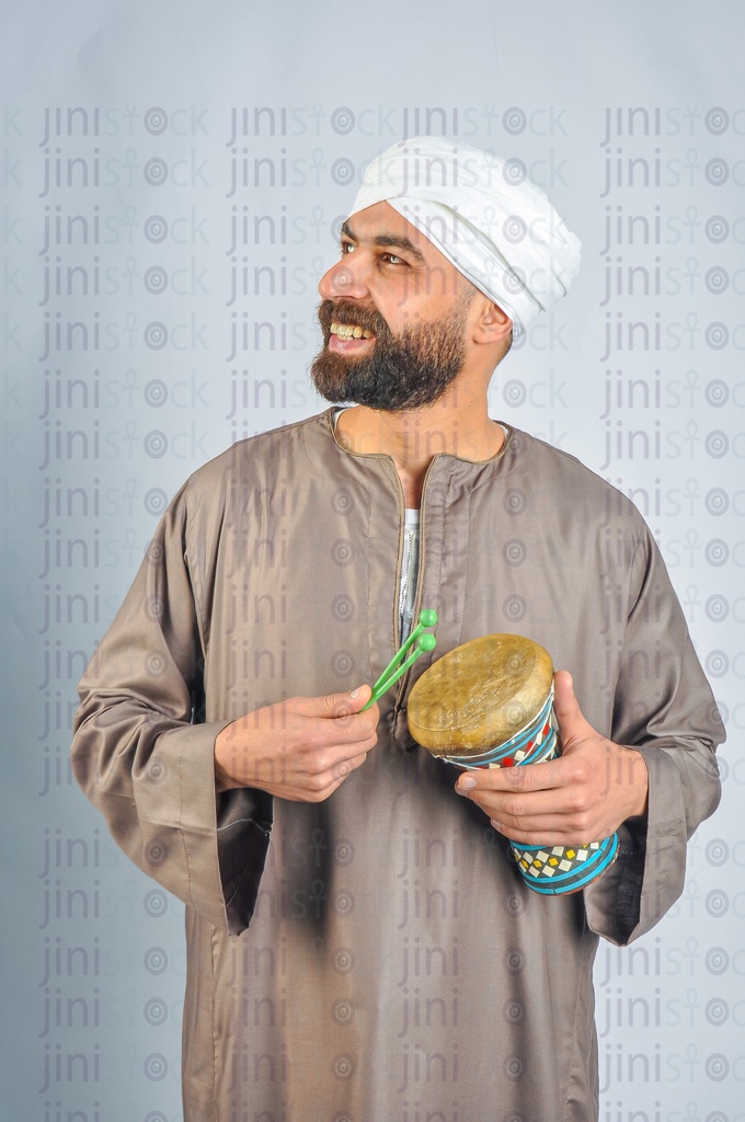 Al Mesaharati holding a drum and drumming