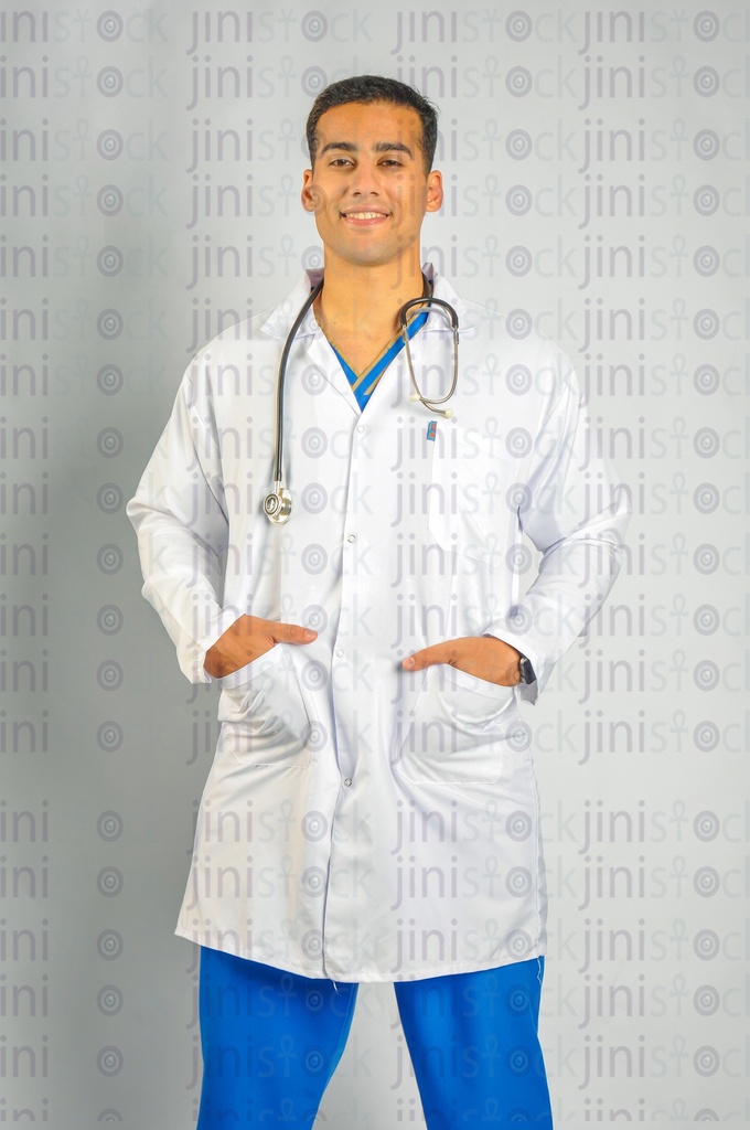 A male Egyptian doctor or physician wearing a white coat and a stethoscope putting his hands in his pockets