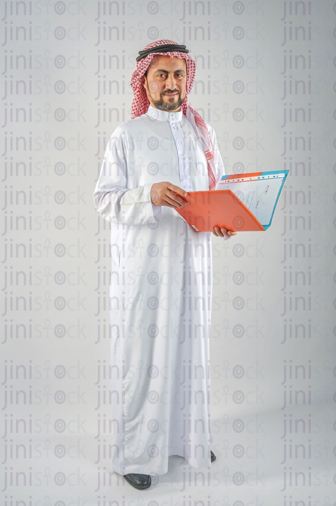 A man from the Gulf Saudi or Emirati holding a folder of work papers and checking it