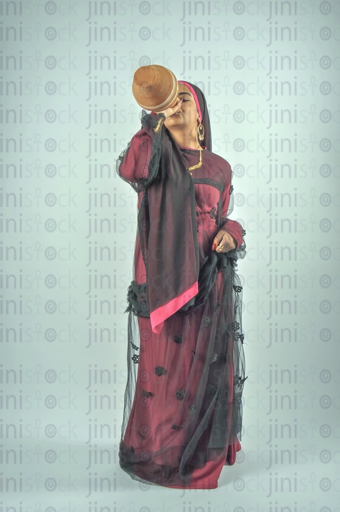 Nubian Egyptian woman wearing Nubian clothes or farmer drinking water from Qola