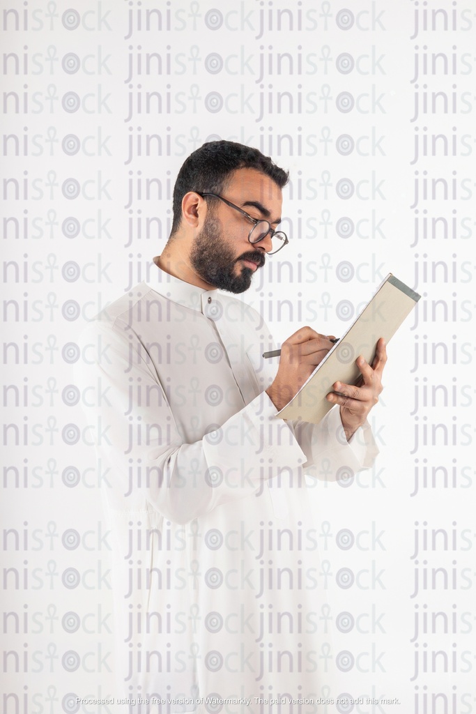 صورة فوتوغرافية لرجل أعمال خليجي سعودي يكتب على الأوراق