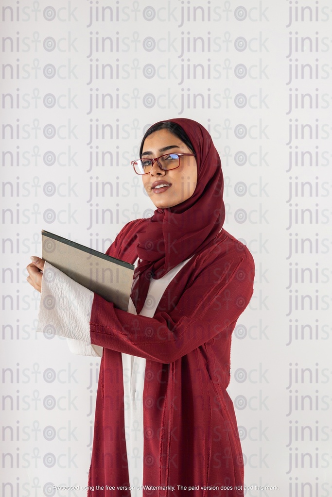 سعودي خليجي يعمل من الخليج يحمل دفتر ملاحظات وينظر إلى الكاميرا