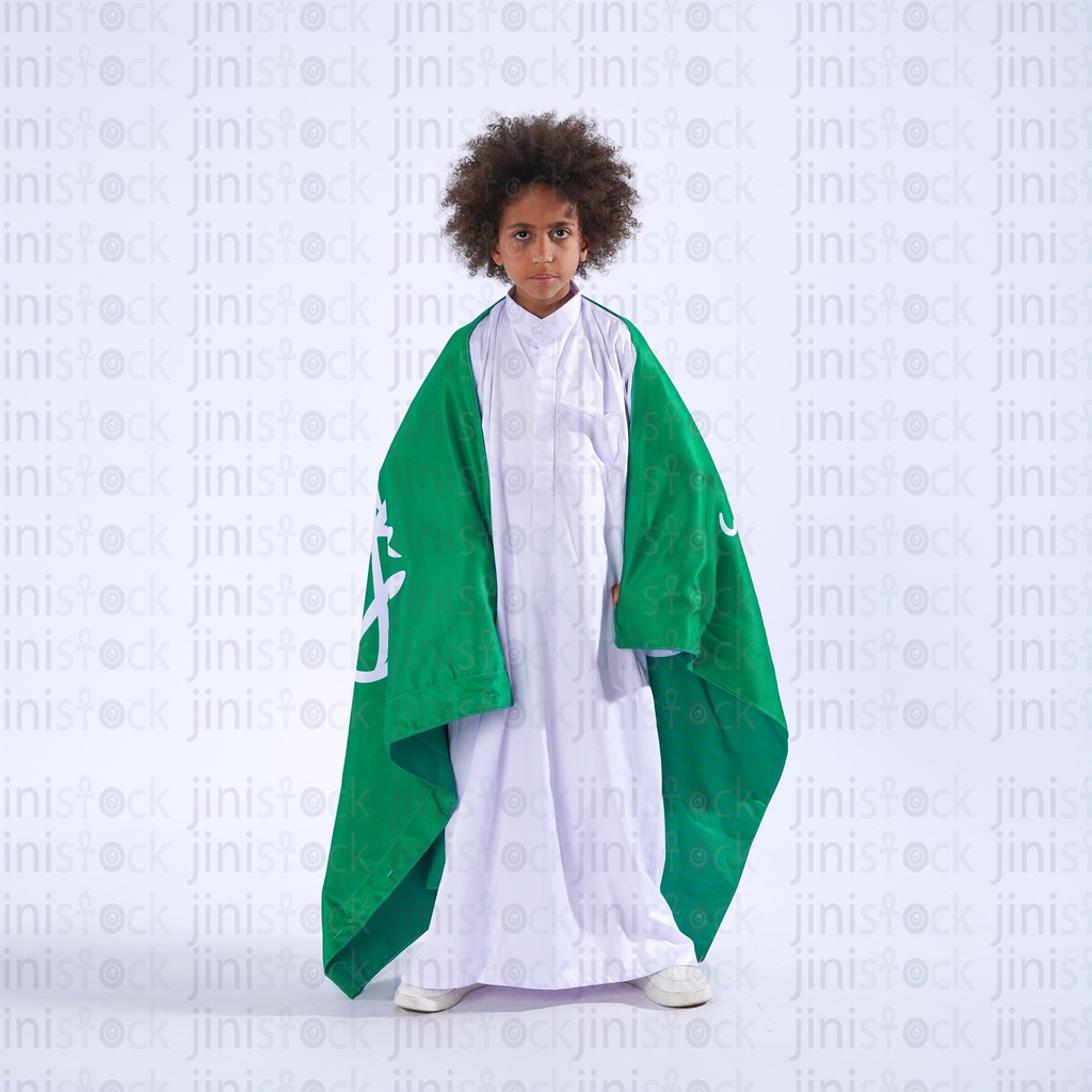 ولد خليجي من السعودية يحمل العلم السعودي على كتفه
